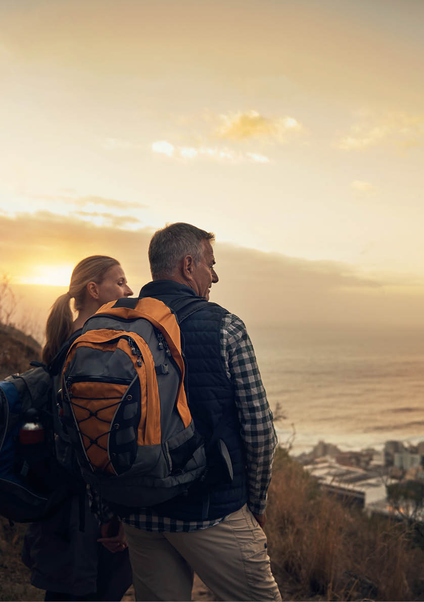 Rearview shot of a mature couple looking at the view hiking through the mountains