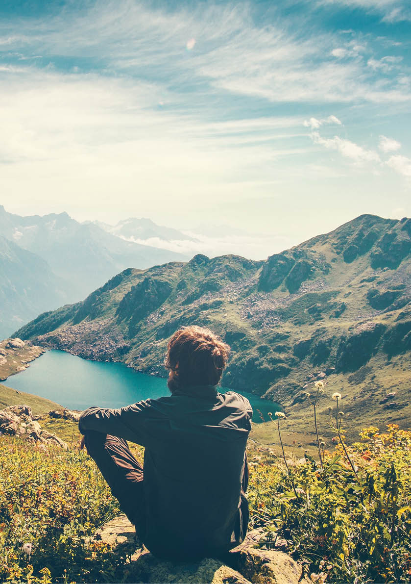 Traveler Man relaxing meditation with serene view mountains and lake landscape Travel Lifestyle hiking concept summer vacations outdoor