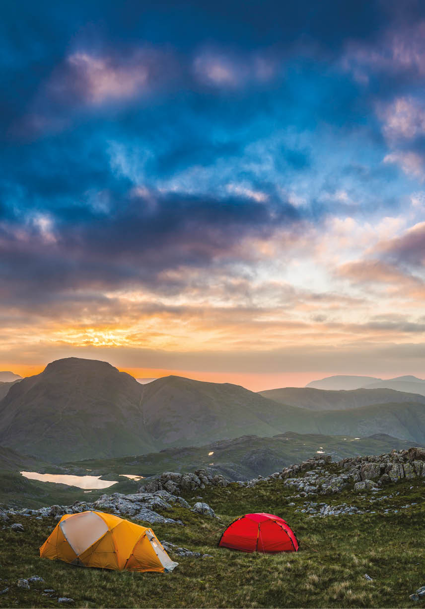 Colourful mountain tents pitched on an idyllic wild camp site high in the Lake District National Park, overlooked by the iconic peaks of Great Gable and Green Gable, Cumbria, UK  ProPhoto RGB profile for maximum color fidelity and gamut 