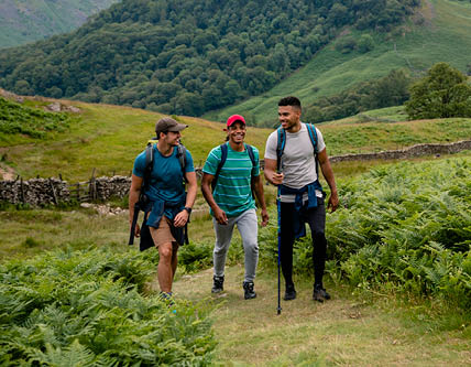 Three young males enjoying a hike in the mountains in The Lake District in Cumbria
