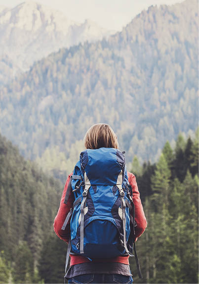 Young girl traveler on a walking route, active lifestyle, hiking and travel concept  Women looking at lake in winter