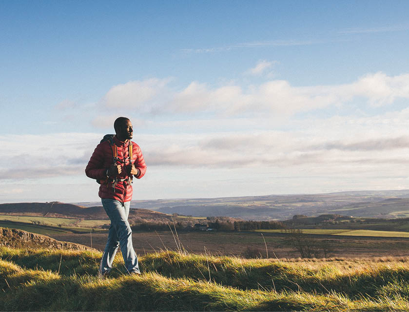 One young adult walking on Hadrian's Wall in Northumberland, UK countryside 