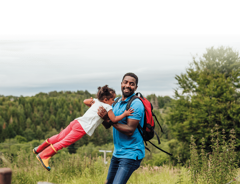 A father swings his daughter round in a circle whilst they are out in a beautiful woodland setting in Hexham.