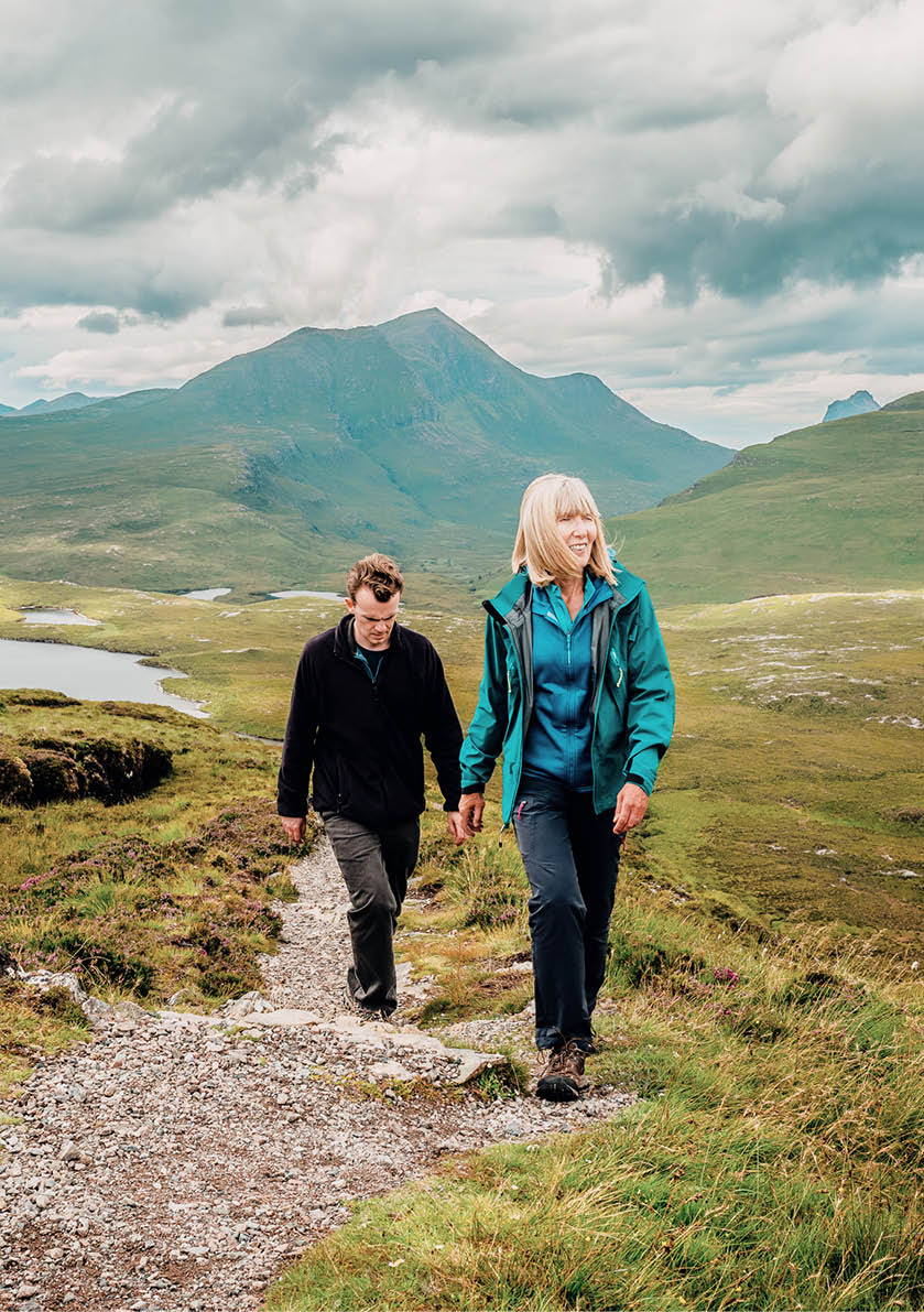 Mature woman and her adult son on the Knockan Crag trail above the Geopark between Ullapool and Elphin in the Assynt region of the Scottish Highlands.