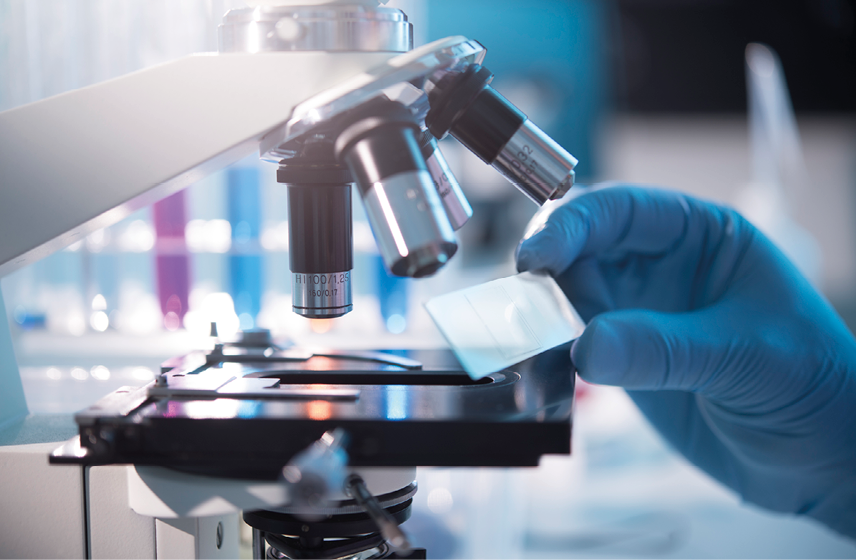 A scientist placing a slide under a microscope