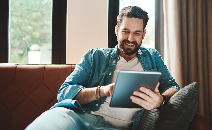 Cropped shot of a handsome young man using a tablet while chilling on the sofa at home