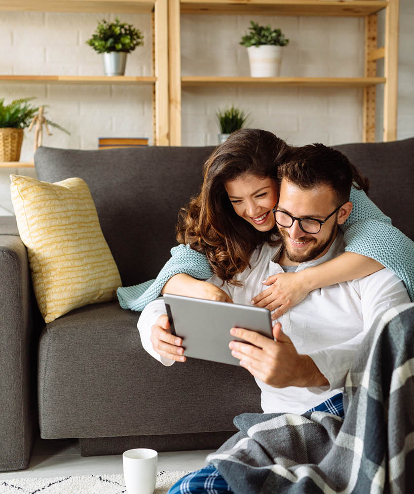 Young couple using digital tablet at home