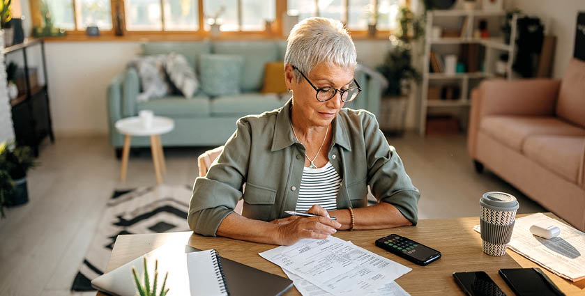 Senior woman calculating her expenses at her apartment